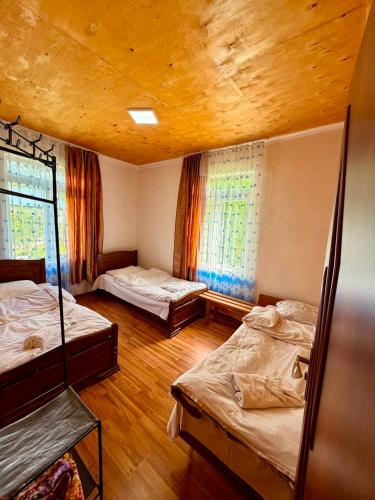 a room with two beds and two windows at Guesthouse Tanano/Dodo in Zhabeshi