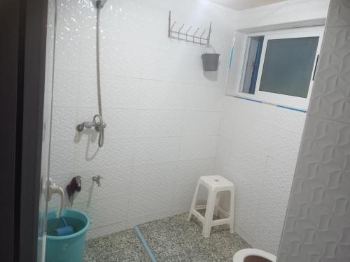 a bathroom with a shower with a stool in it at Tamraght banana house in Agadir