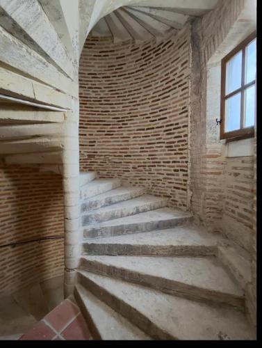 an empty room with brick walls and stairs at Tour Médiévale Unesco in Albi