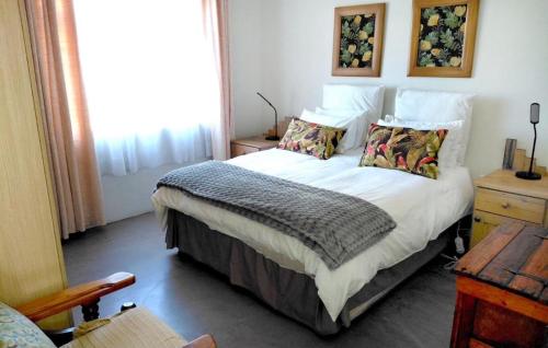 a bedroom with a large bed with pillows at Shallow Pig Cottage in Parys
