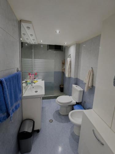 a bathroom with a white toilet and a sink and a toilet istg at SiMar Apartment Tirana in Kashari