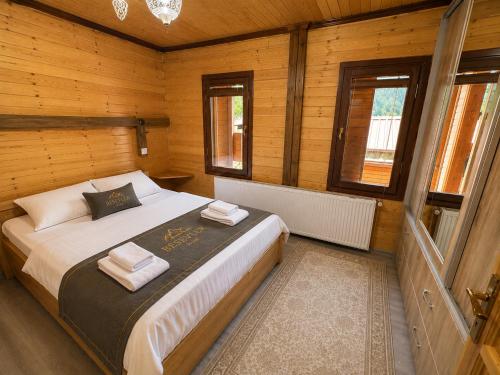 a bedroom with a bed with two towels on it at Beş Evler Apart in Uzungöl