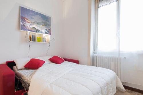 una camera da letto con un letto con cuscini rossi di Mauro's Studio a Milano