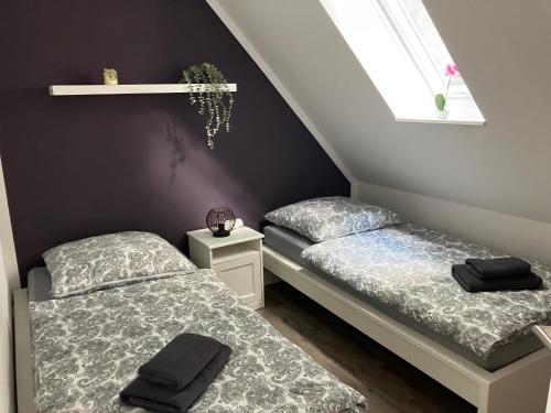 two twin beds in a room with stairs at Ferienwohnung am Woezer See in Woez