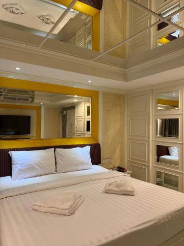 a bedroom with a large bed with two towels on it at Nava Grand in Ban Talat Rangsit