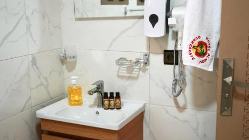 a bathroom sink with a soap dispenser on it at Hotel Almou in Ouarzazate