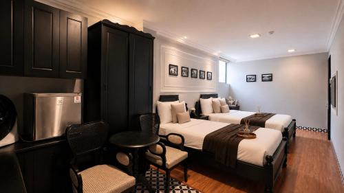 a hotel room with two beds and a table and chairs at TTR Skypool View Hotel - Đà lạt in Da Lat