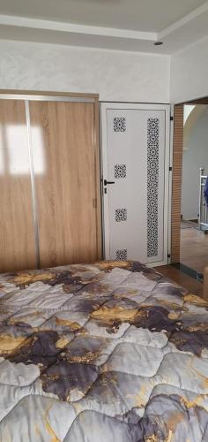 a bedroom with a large bed and a door at La maison blanche in Tinerhir