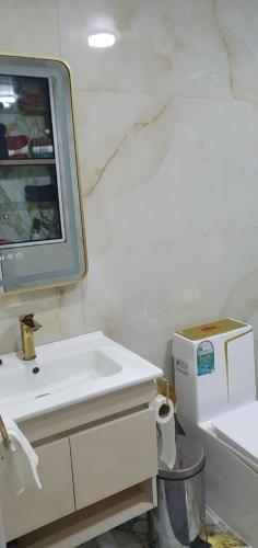 a bathroom with a sink and a tv on the wall at La maison blanche in Tinerhir