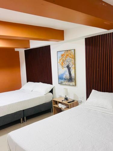a bedroom with two beds and a painting on the wall at Mosaico Cartagena Hotel in Cartagena de Indias