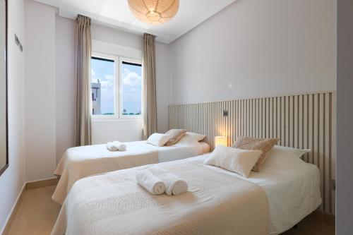 a bedroom with two beds with towels on them at Casa Avina Bliss in Los Alcázares