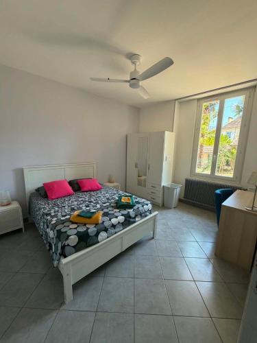 a bedroom with a bed with two red pillows at Les Palmiers in Millau