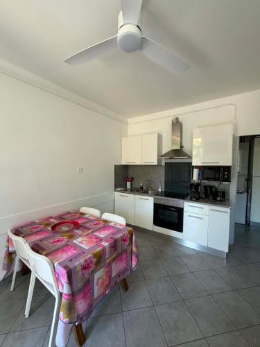a kitchen with a table and a kitchen with white cabinets at Les Palmiers in Millau