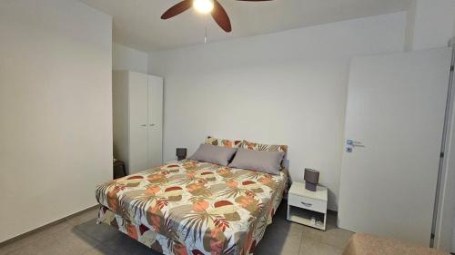 a bedroom with a bed and a ceiling fan at Casa Rose in Villaggio Azzurro
