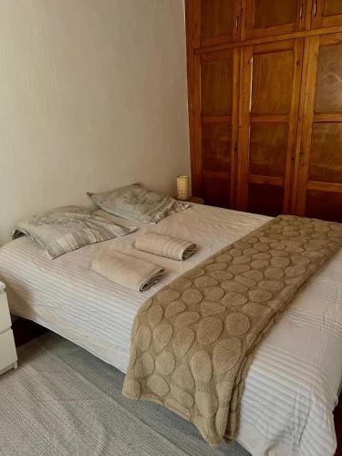 a bedroom with a large white bed with a wooden cabinet at Charmant in Saint-Martin-Vésubie