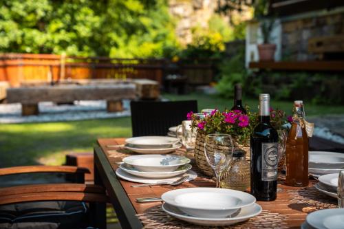 a wooden table with plates and bottles of wine at Chalupa 47 in Hřensko