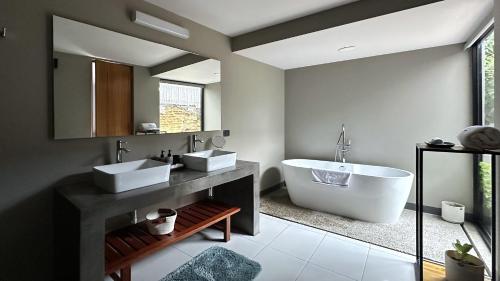 ein Badezimmer mit zwei Waschbecken und einer Badewanne in der Unterkunft Casa Olié in Oaxaca de Juárez