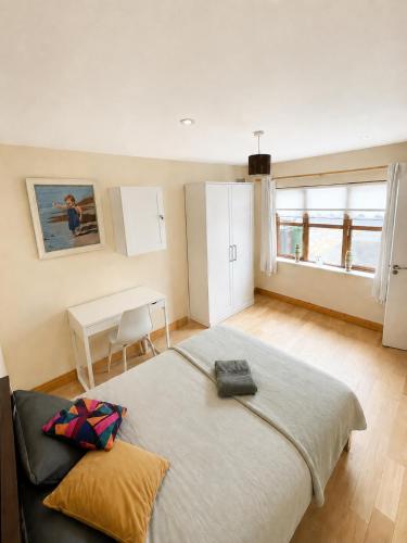 a bedroom with a large bed and a table at 28 Rathevan View Rosdarragh Portlaoise in Portlaoise