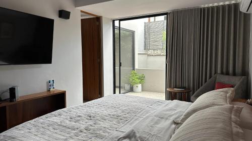 ein Schlafzimmer mit einem großen Bett und einem großen Fenster in der Unterkunft Casa Olié in Oaxaca de Juárez