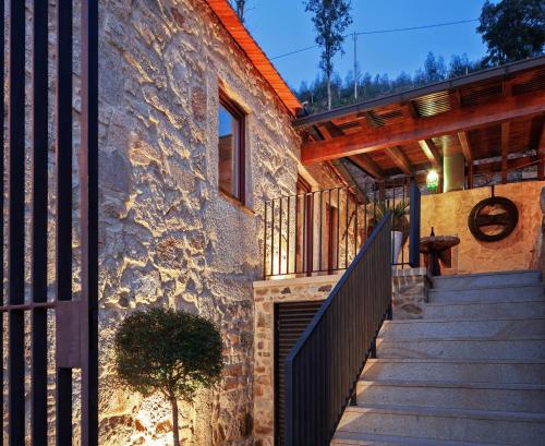 a stone house with a staircase leading up to it at Casa do Avô in Cinfães