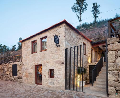 an old stone building with a black gate at Casa do Avô in Cinfães