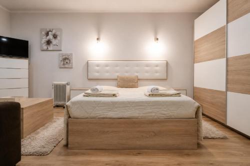 a bedroom with a large bed and a flat screen tv at Imperial apartment 1, 2 e 3 in Braga