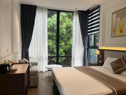 a hotel room with a bed and a large window at Trang An Heritage Hotel in Nguyên Ngoại