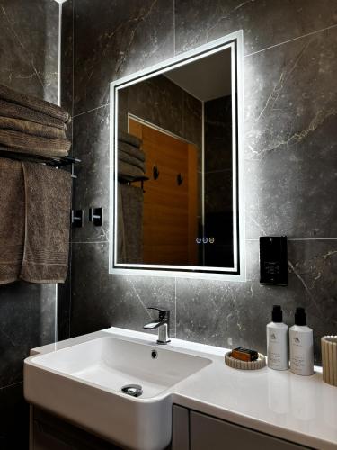 a bathroom with a white sink and a mirror at Cadderlie Cabin - Luxury Woodland Escape with Hot Tub Near Oban in Oban