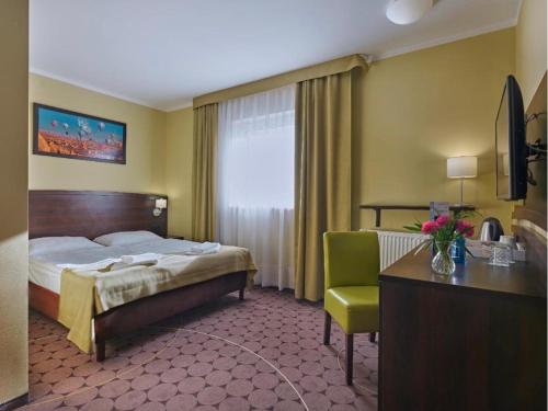 a hotel room with a bed and a chair at Lumen in Krakow