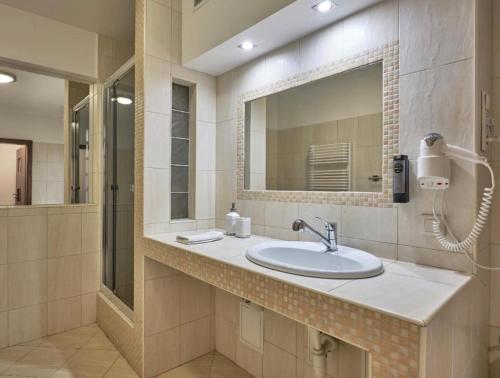 a bathroom with a sink and a mirror at Lumen in Krakow