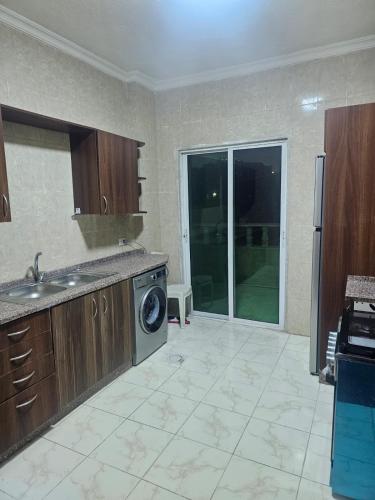 a kitchen with a sink and a washing machine at الجبيهه شفابدران شقة مفروشة in Amman
