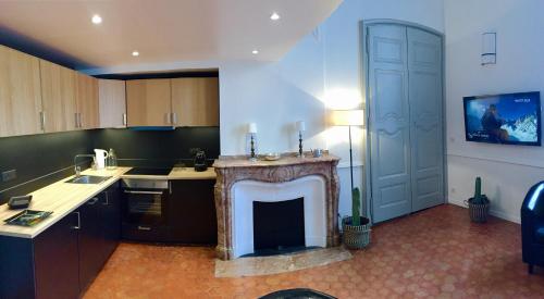 a kitchen with a fireplace in the middle of a room at Les Suites du Cours & Spa in Aix-en-Provence