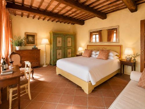 a bedroom with a bed and a table and a desk at Borgo Livernano in Radda in Chianti