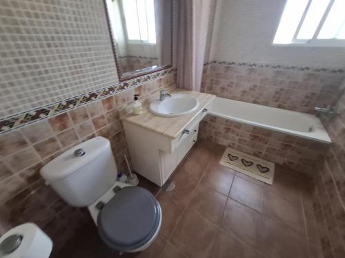 a bathroom with a toilet and a sink and a tub at Ático Playa in Cartagena