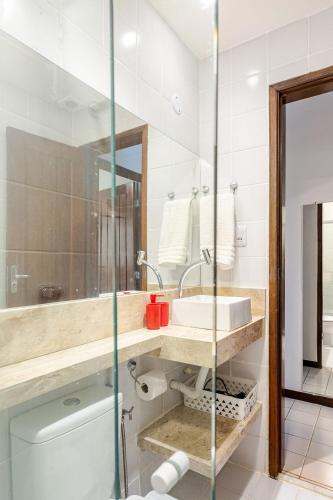 a bathroom with a sink and a mirror at Guarajuba, apart 1/4 próximo à praia in Guarajuba