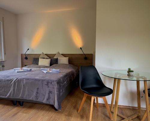 a bedroom with a bed and a glass table at Frankenstube in Eichelsdorf