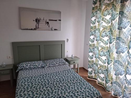 a bedroom with a bed and a large window at Ático Playa in Cartagena