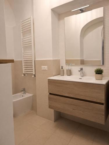 a bathroom with a sink and a tub and a mirror at Suite Il Mulino - Sea View in Sperlonga