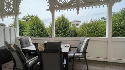 a porch with a table and chairs and a gazebo at Villa Sonneck, App 07 - Bade- & Saunawelt täglich inklusive in Ostseebad Sellin