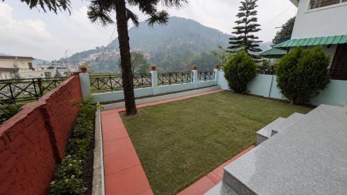 a garden with a view of a mountain at Kumaon Breeze homestay in Bhowāli