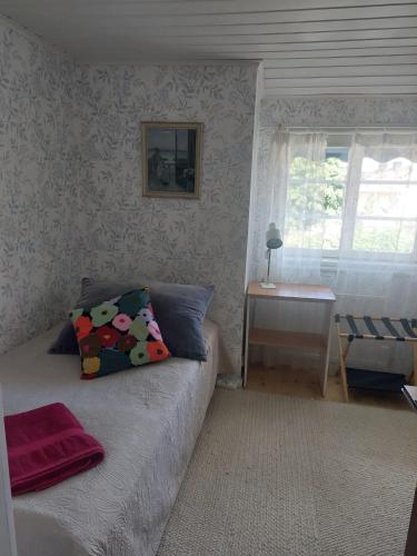 a bedroom with a bed and a table and a window at Guest room in Uppsala