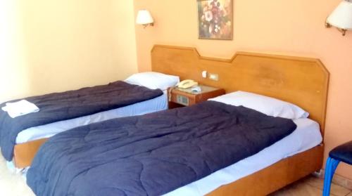 a hotel room with two beds and a telephone at New Radwan Hotel, Luxor railways in Luxor