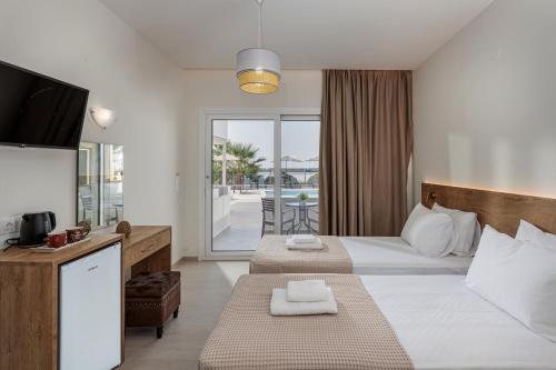 a hotel room with two beds and a balcony at Amara Cove Adults Only by Estia in Malia