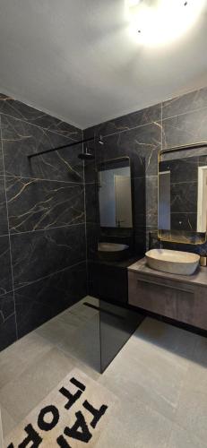 a bathroom with two sinks and two mirrors at Malo misto in Kovačić