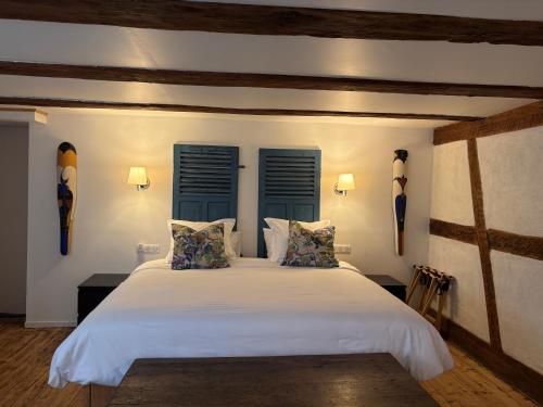 a bedroom with a large white bed with blue shutters at En Passant in Dambach