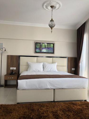 a bedroom with a large white bed and a chandelier at EnkayaHotel in Nicosia