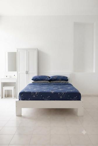 a bed with blue pillows in a white room at MSM DIAMOND guesthouse 1 in Male City