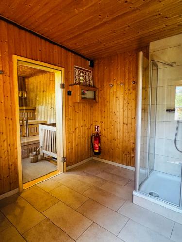 a bathroom with a walk in shower and a glass door at ALPIN- Das Sporthotel, SUMMERCARD included May - September in Zell am See