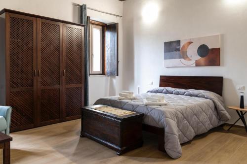 a bedroom with a bed and a wooden cabinet at Palazzo Menghina in Casaletto Spartano