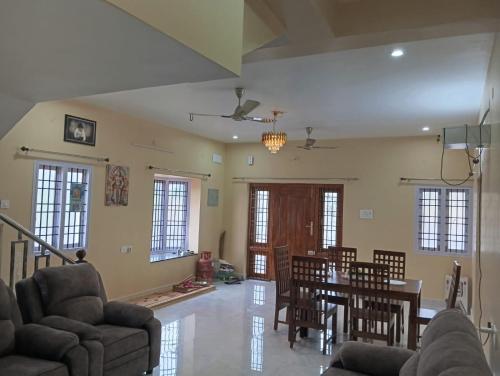 a living room with a dining room table and chairs at Malliga Farm House in Turinjāpuram